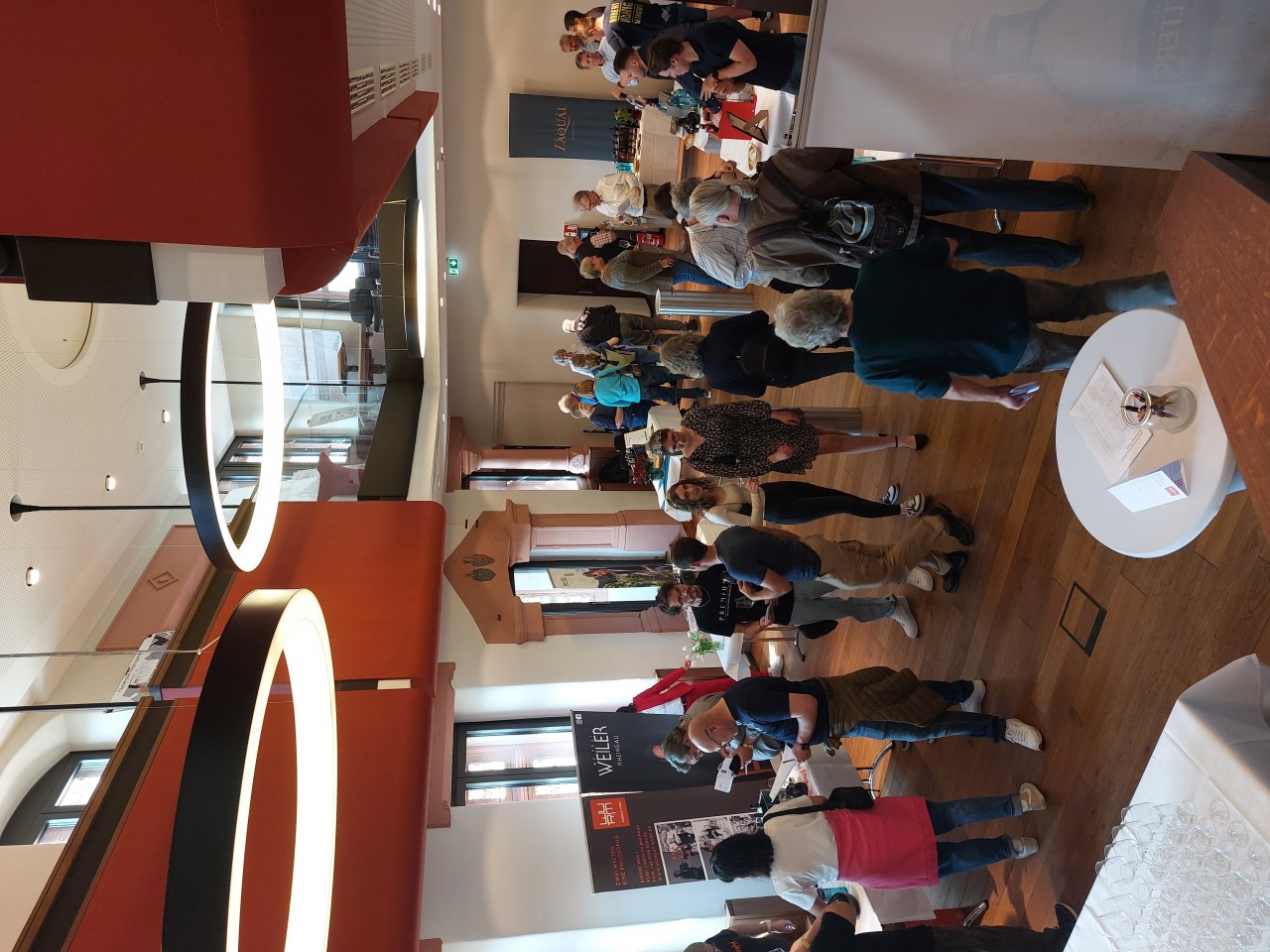 Der Rittersaal im Hilchenhaus mit Personen, die Wein probieren.